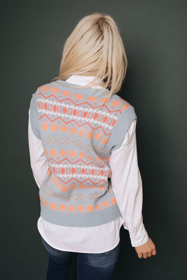 Back view of V-neck knitted sweater vest in light gray with orange tribal pattern