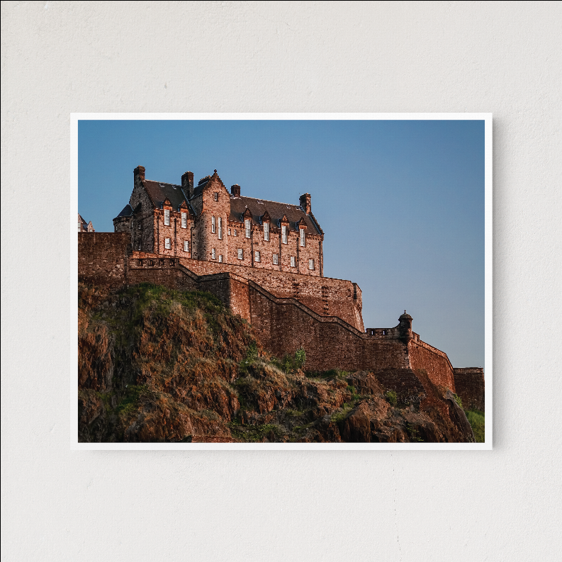 White-matted framed castle landscape with blue sky and fortress on cliff