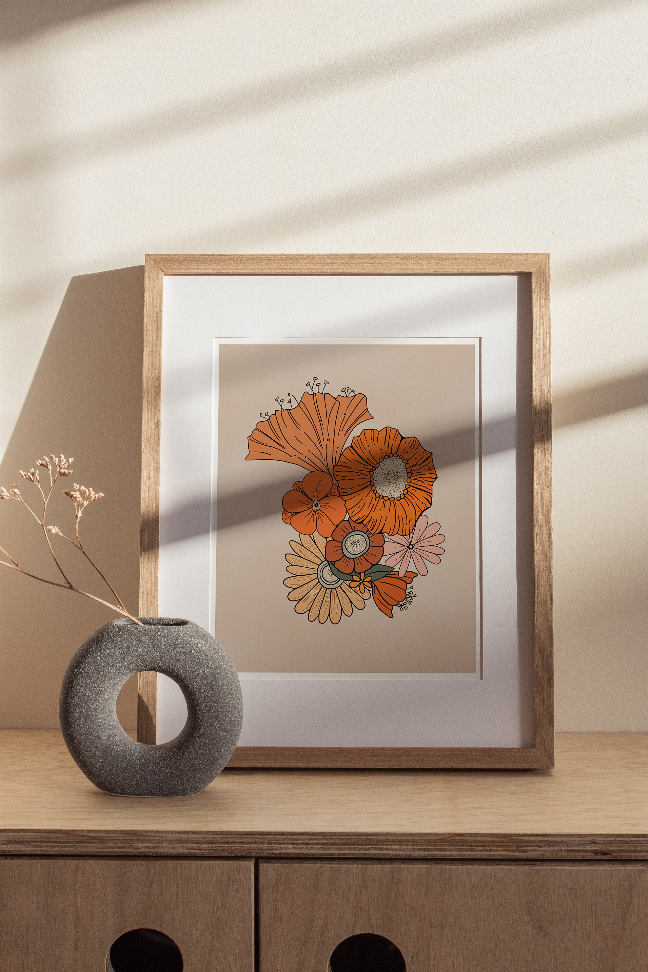 Framed retro floral wall art print with orange flowers in light wood frame, gray ring decor in front