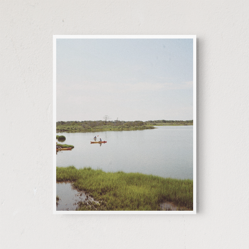 Framed lake landscape wall art with small boats on still water and green shoreline