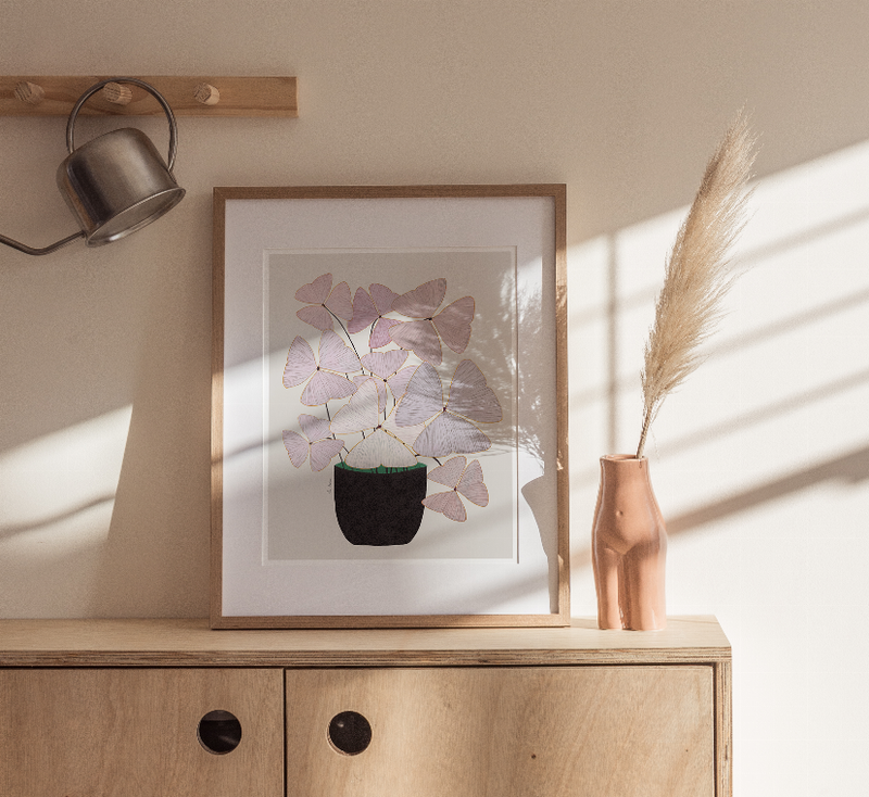 Framed floral artwork with pastel blossoms and a dark planter in a white border frame