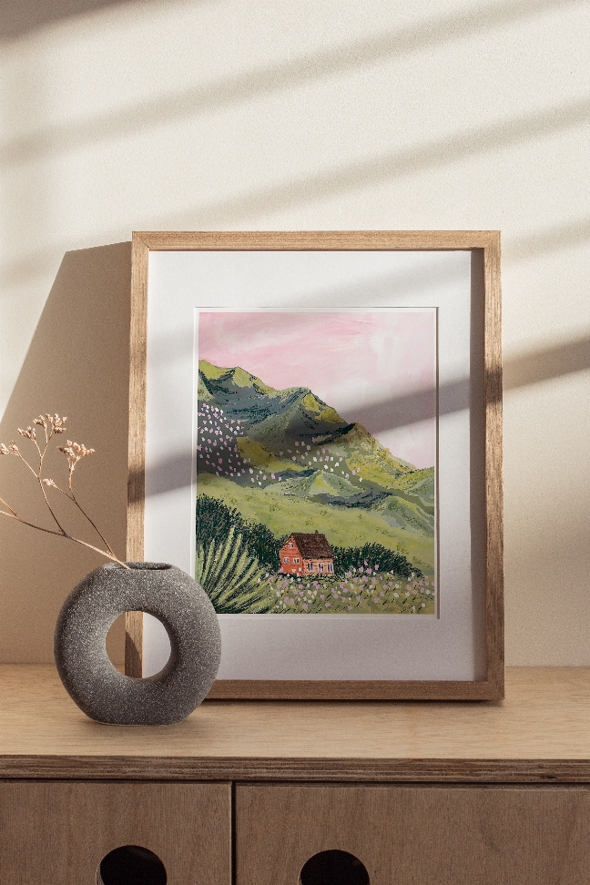 Framed mountain village wall art with circular ornament in front of the frame