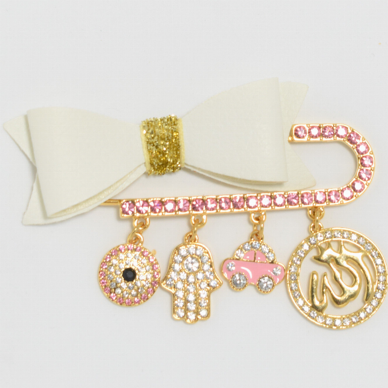 Baby hair pin with cream bow and gold center, pink rhinestone charm dangles