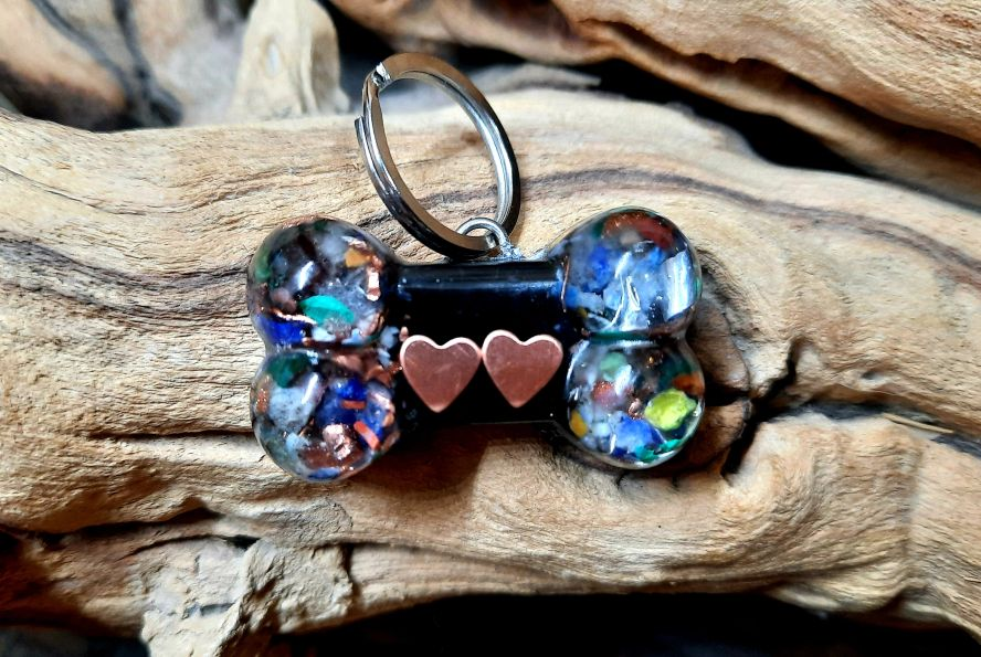 Dog bone pet charm keychain with blue iridescent beads, heart cutouts, and metal ring