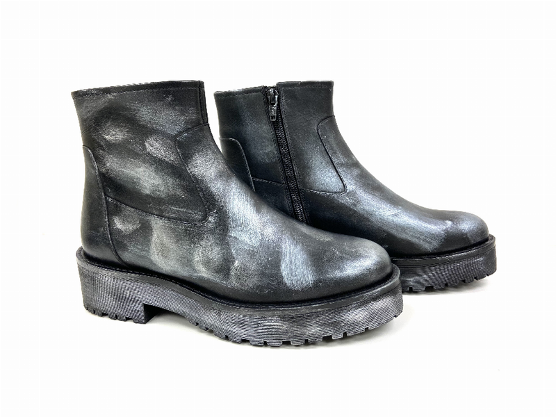 Pair of black ankle booties with side zippers and chunky lug soles, leather look