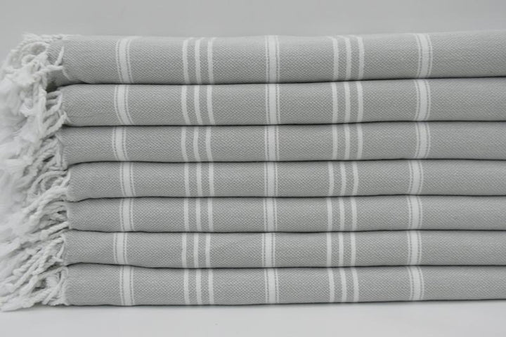 Folded gray striped hand towel set with fringed border edge