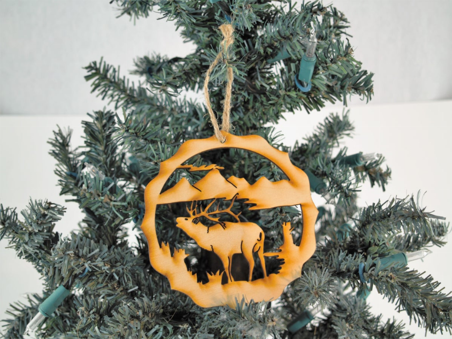 Elk unfinished round tree ornament with deer silhouette cutout in orange frame