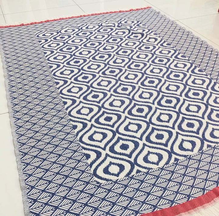 Turkish geometric throw blanket in navy and white with red edge and tasseled fringe