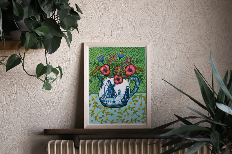 Framed wall art print with a blue sailboat and bright floral accents on green geometric design