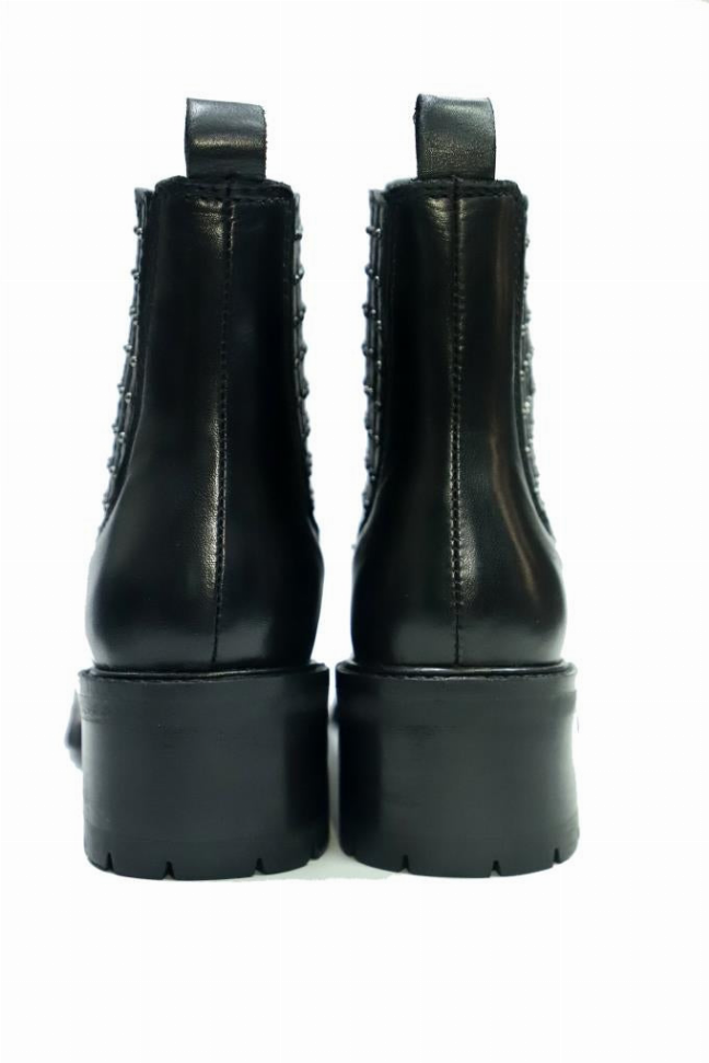 Black Chelsea boots with elastic sides and thick platform tread soles, rear view