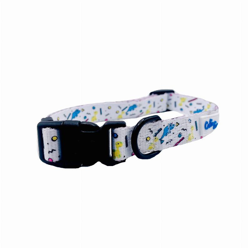 Dog collar close-up of black clasp and light gray dinosaur confetti print strap