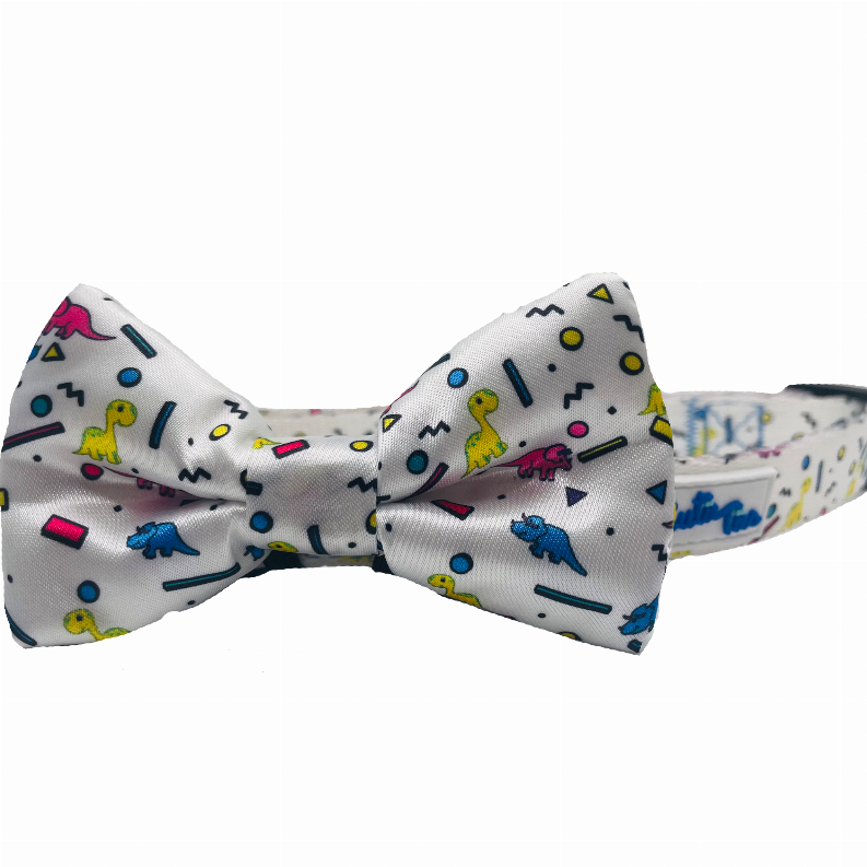 Dog collar bow tie in light gray with colorful dinosaur icons, attached to matching strap