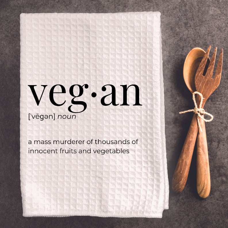 White tea towel folded with 'veg·an' print and quote about fruits and vegetables