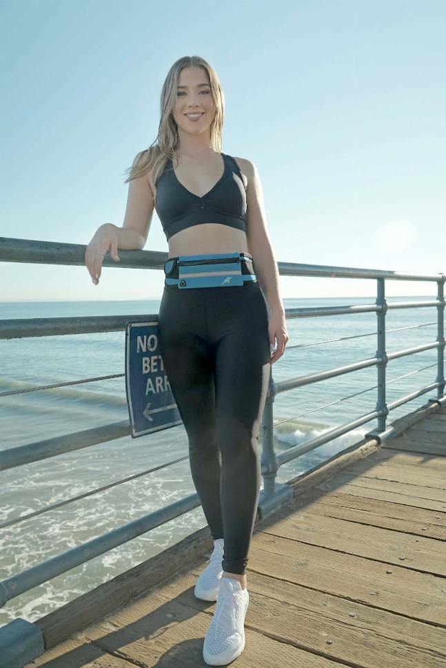 Teal running waist pack worn at the hip over black leggings