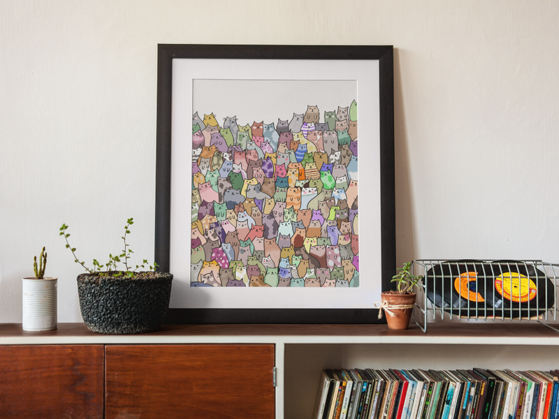Framed cat wall art print with white mat and multicolor cat faces pattern
