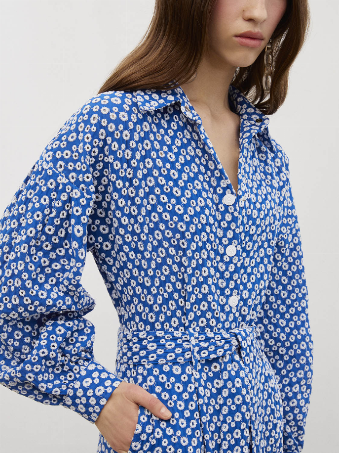 Royal blue patterned jumpsuit with self-belt waist, long sleeves, and buttoned neckline