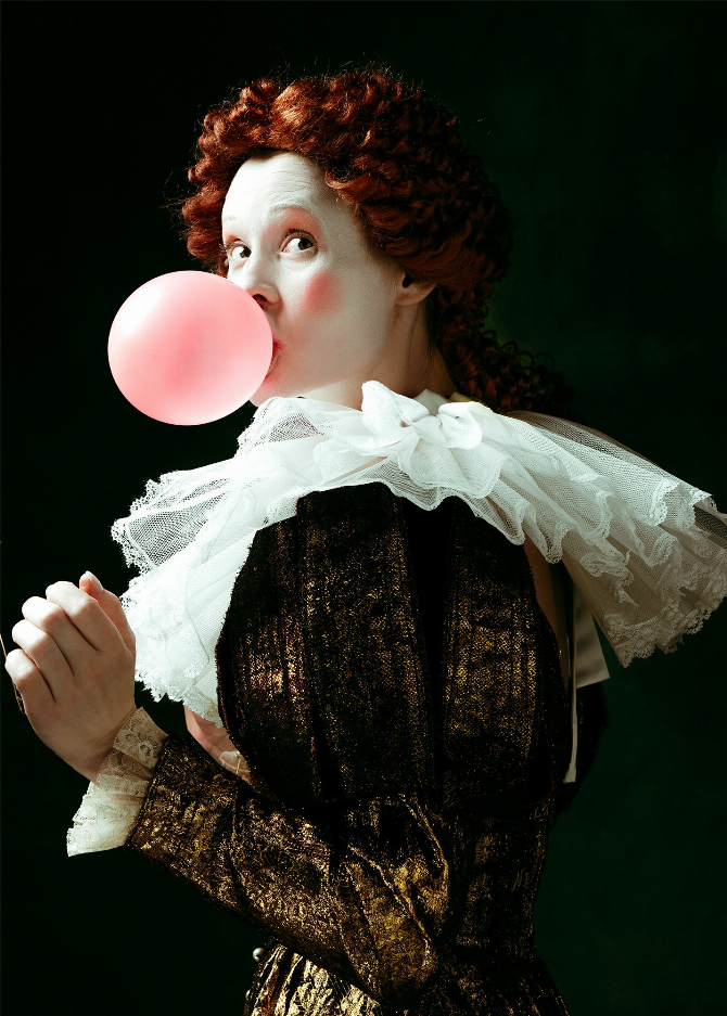 Victorian wall art close-up: red-haired doll holding pink bubble, white lace collar, dark bodice