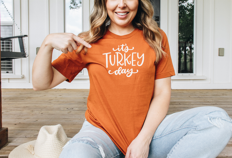 Orange short-sleeve crewneck T-shirt with white 'It's TURKEY day' logo