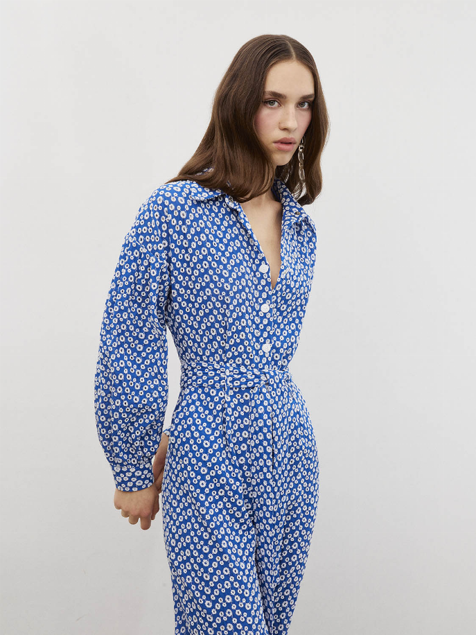 Blue eyelet jumpsuit side view with self-belt waist and long sleeves