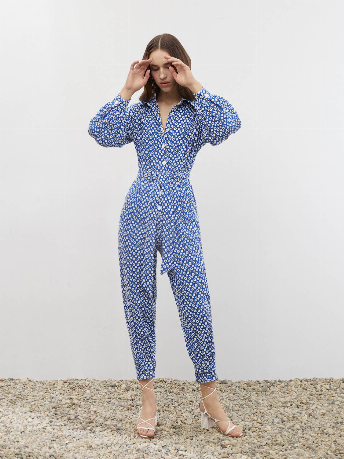 Blue eyelet self-belt jumpsuit with long sleeves, V-neck, and tapered legs