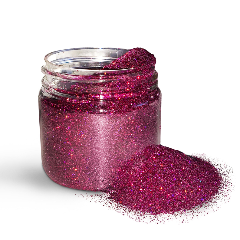 Magenta holographic body glitter powder jar with glitter spill on surface