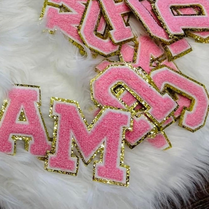 Pink alphabet letter applique with gold trim on fuzzy sweatshirt