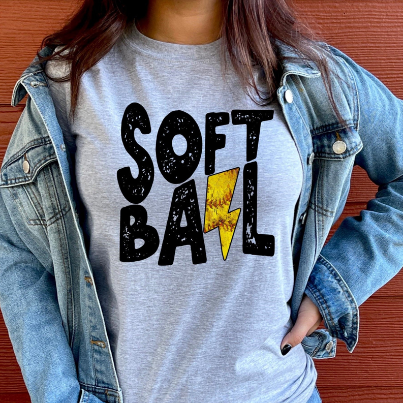 Heather gray t-shirt with bold 'SOFT BALL' print and yellow bolt graphic
