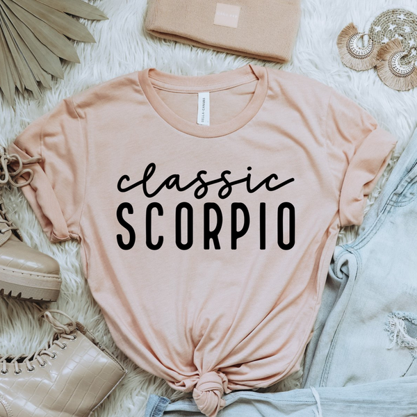 Peach women’s T-shirt with black “classic scorpio” zodiac text, crew neck