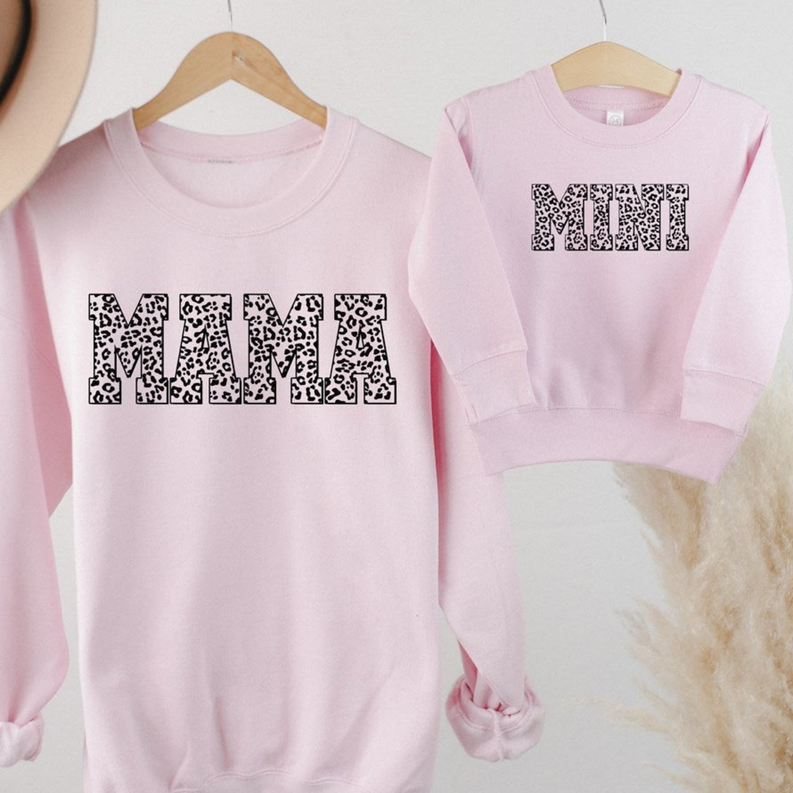 Light pink crewneck sweatshirt with leopard-pattern letter graphic and long sleeves