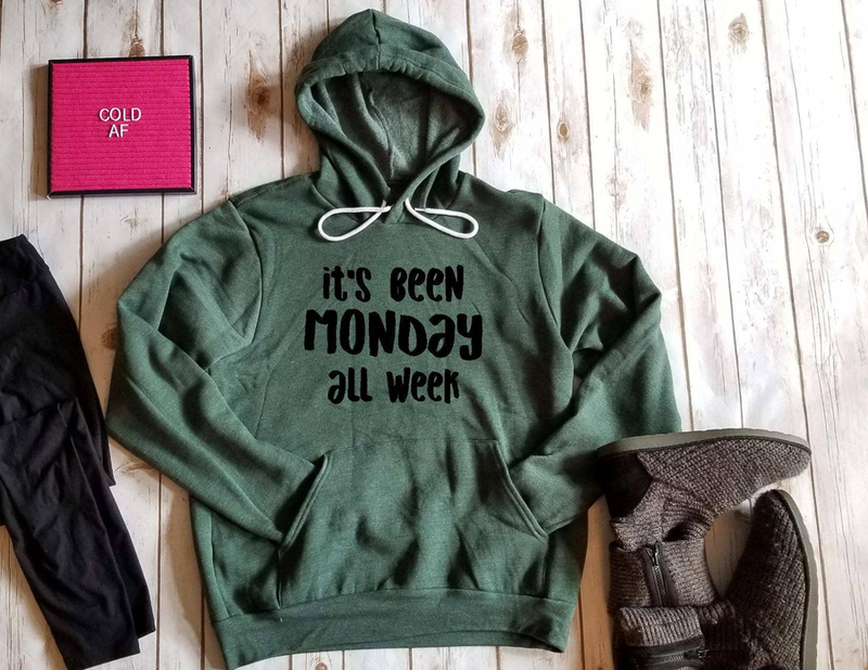 Green hoodie sweatshirt with front pocket and graphic text reading 'It's been Monday all week'.
