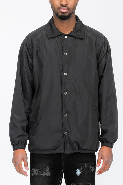 Black coach jacket with button front, collar, and elastic cuffs.