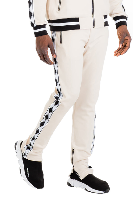 Off-white track pants with zip pockets, black stripe panels, ankle cuffs