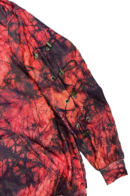 Red and black graphic pullover hoodie detail with side toggle hardware and cords.