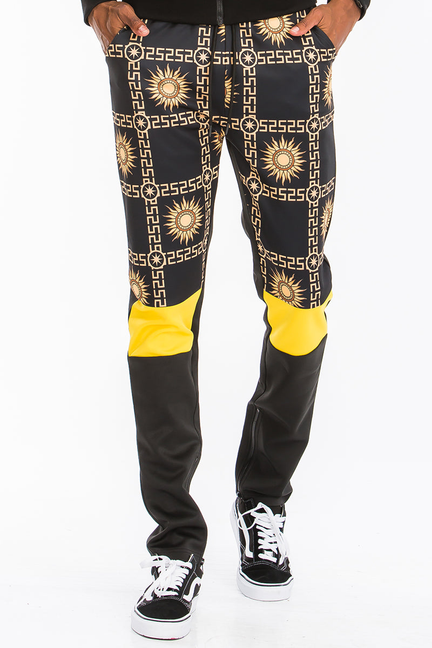 Men's black track pants with gold geometric print and bright yellow cuffs at hem