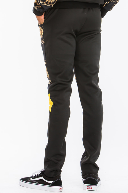 Men's black track pants with gold geometric logo print and yellow ankle cuffs