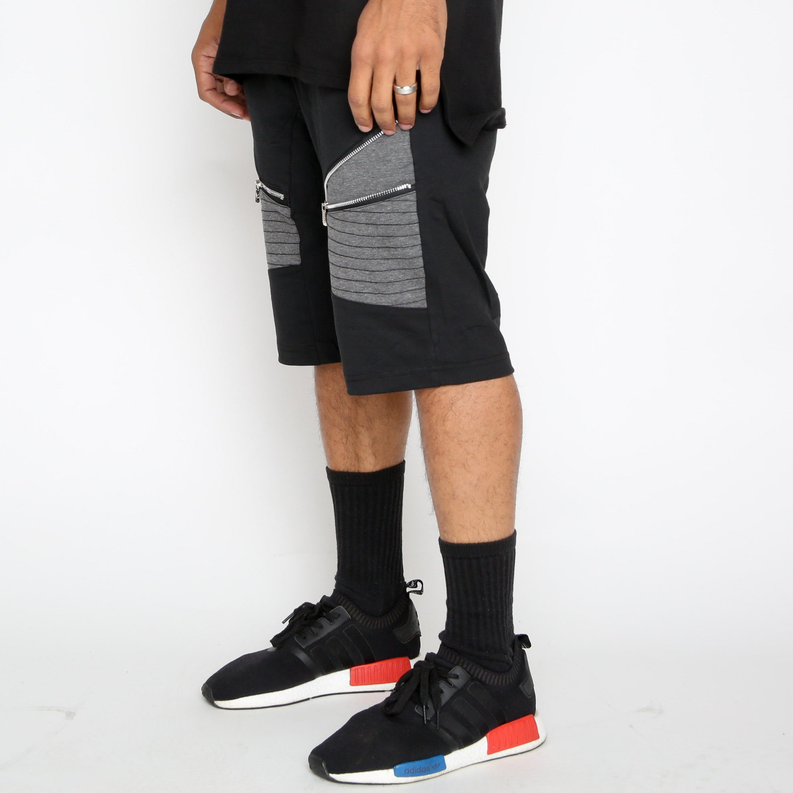 Black moto shorts with gray panel and zip pocket detail on the side; knee-length view