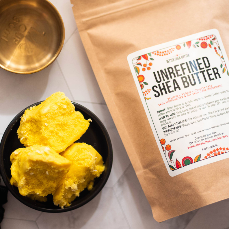 Yellow shea butter chunks in bowl with kraft paper pouch