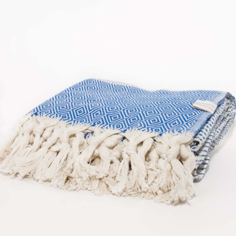 Geometric blue towel with cream fringed edge, folded