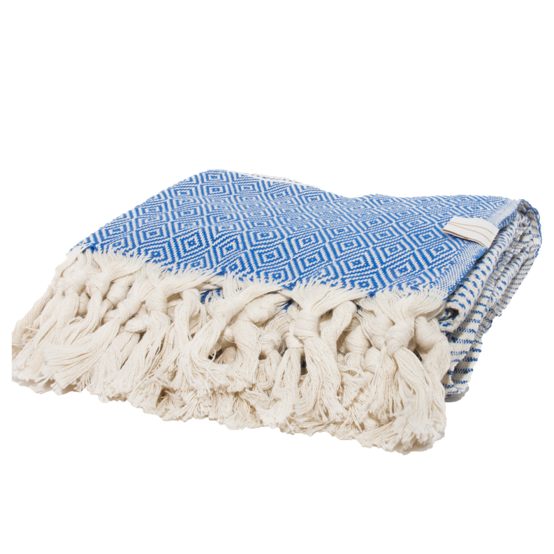 Folded towel with blue geometric center and cream tassel fringe