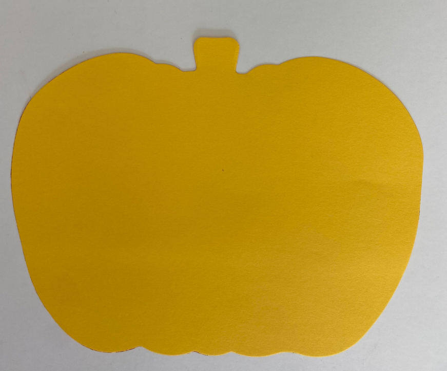 Yellow pumpkin cut-out with a small stem, plain surface