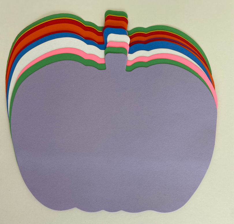 Stacked pumpkin cut-outs in rainbow bands with a purple front layer
