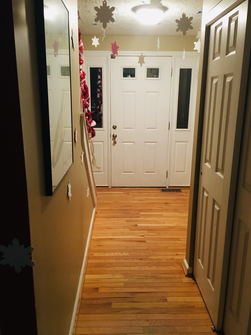 White foam snowflake cut-outs on hallway wall, multiple shapes