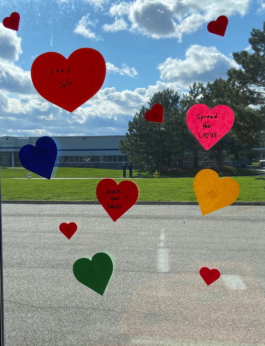 Assorted heart cut-outs in red, blue, green, and yellow on a surface