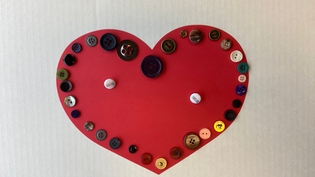 Red heart cut-out decorated with assorted buttons and small round accents