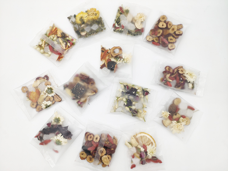 Loose tea packages with assorted dried flowers and fruit in clear sealed sachets