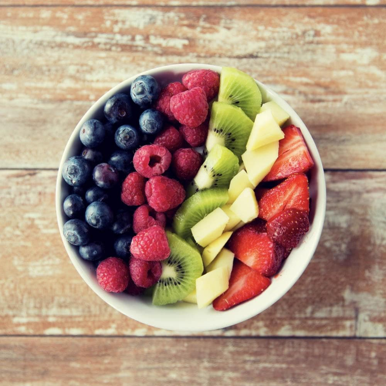 Fruit bowl with berries, melon, and citrus fruit for cane sugar topping