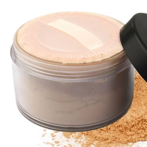 Mineral powder container showing pale beige powder on lid and spilled grains