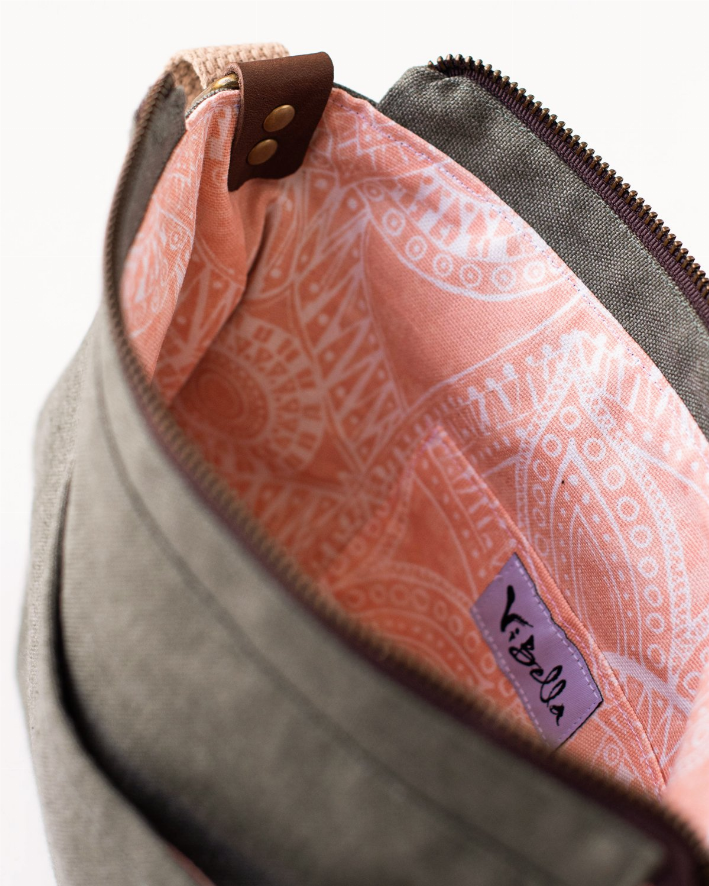 Olive crossbody bag interior with pink patterned lining and purple logo patch