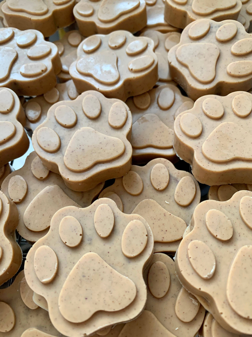 Paw-shaped dog treats, beige with subtle speckled texture