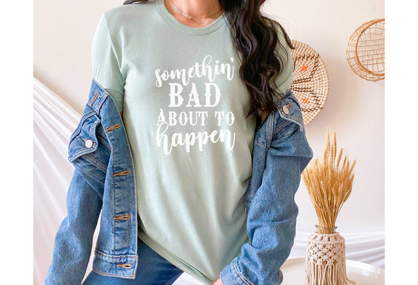 Dusty blue graphic t-shirt with 'somethin' BAD about to happen' text